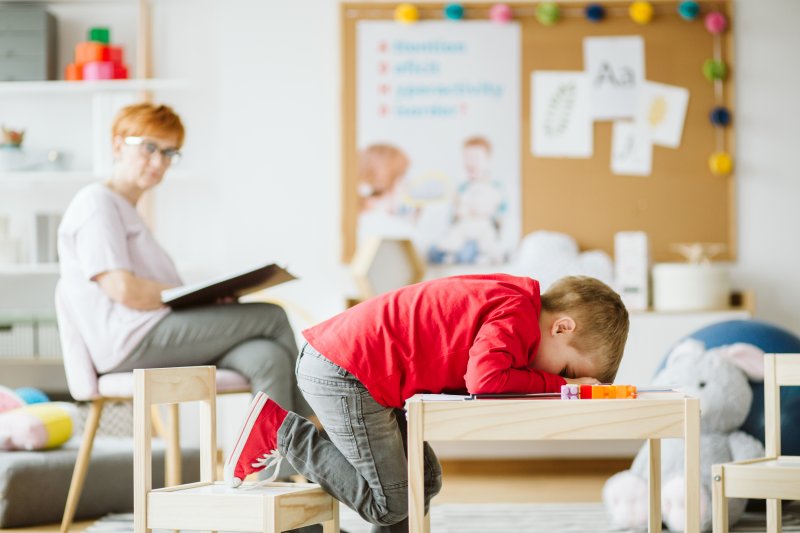 young child sleep at desk in school 