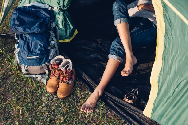 young woman sleeping outdoors in tent