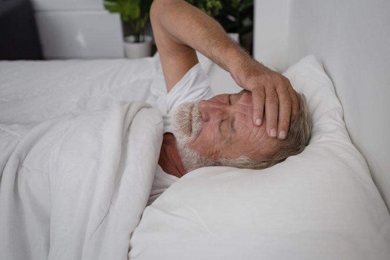 older man laying in bed 