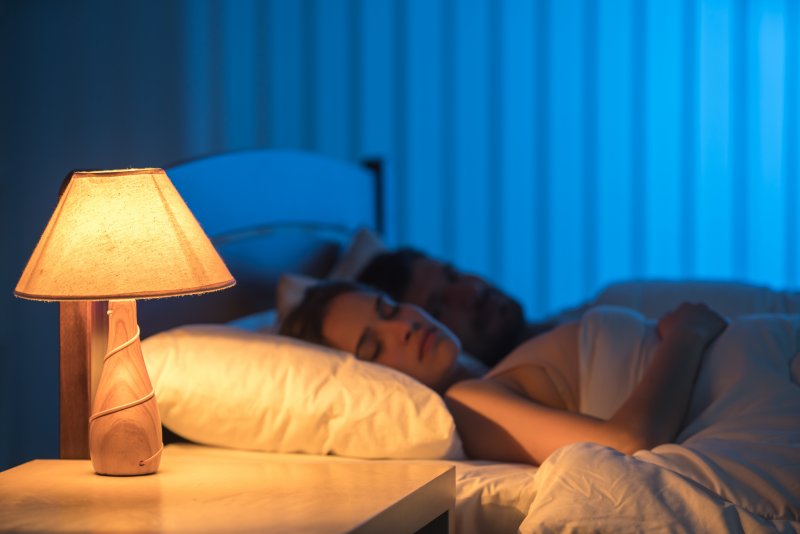 woman sleeping next to lamp