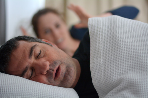 man snoring while partner is awake 