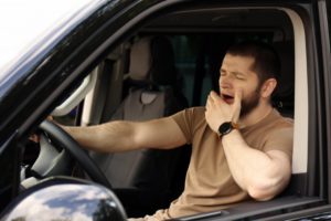 yawning man in the driver’s seat of a car