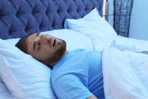 Man with sleep apnea snoring during the night