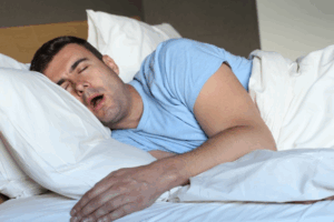 Man snoring while sleeping in his bed